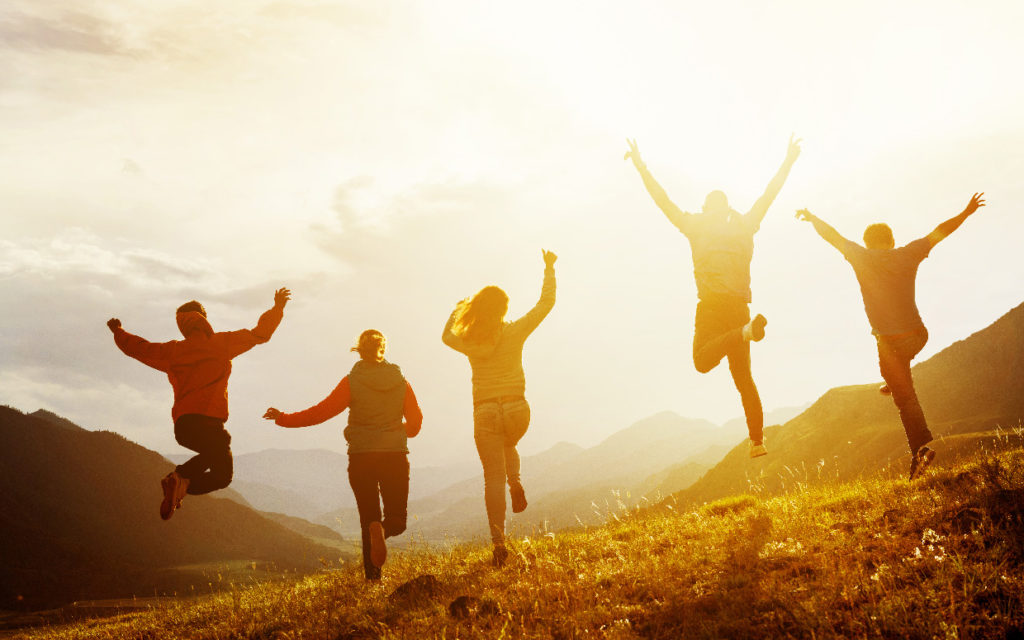 Group of happy friends run and jump